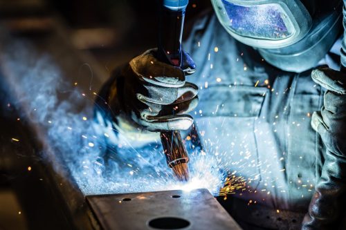 Industriële werkzaamheden met lasser en vonken in beeld