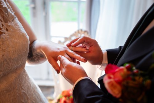 Close-up van handen tijdens het omdoen van de trouwringen