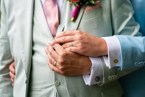 Detail van handen van het bruidspaar tijdens een intiem moment