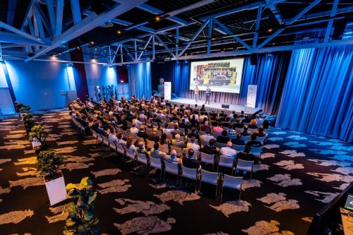Evenementenfotografie van seminar met volledige zaal en podium